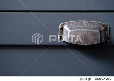 Stylish metal matte furniture handle on facade of gray kitchen cabinet, selective focus 86052505