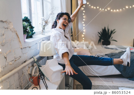 Delighted female with outstretched arms in room Delighted female with outstretched arms in room 86053524