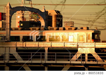 夕日を浴びて隅田川橋梁を渡る東武鉄道350型特急きりふり号 86053830