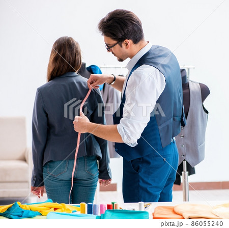 Professional tailor taking measurements for formal suit 86055240