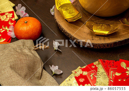 Above view accessories of Chinese new year or Mood day festival oranges gold and Angpao pockets whit cherry blossom branch decorations. Above view accessories of Chinese new year or Mood day festival oranges gold and Angpao pockets whit cherry blossom branch decorations. 86057555