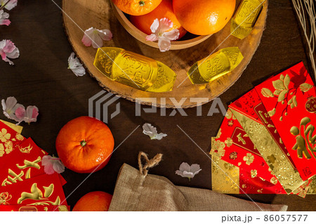 Above view accessories of Chinese new year or Mood day festival oranges gold and Angpao pockets whit cherry blossom branch decorations. Above view accessories of Chinese new year or Mood day festival oranges gold and Angpao pockets whit cherry blossom branch decorations. 86057577