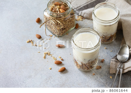Healthy breakfast, yogurt parfait. Yogurt with homemade almond granola on a gray concrete background. Copy space. Healthy breakfast, yogurt parfait. Yogurt with homemade almond granola on a gray concrete background. Copy space. 86061644