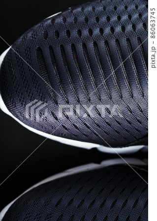 Black and white ultra-modern sports sneakers on a black background. 86063745