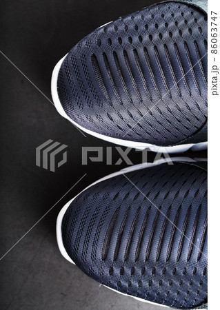 Black and white ultra-modern sports sneakers on a black background. 86063747