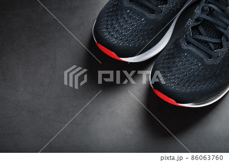 Black sports sneakers with red soles on a black background. Black sports sneakers with red soles on a black background. 86063760