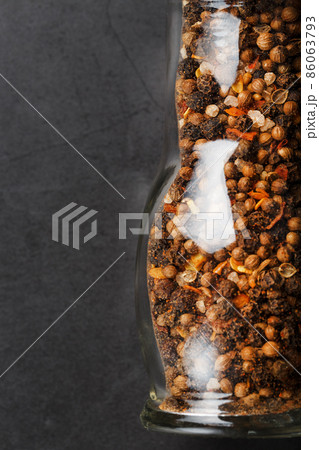 Seasoning mixture in glass mill on black background 86063793