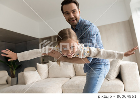 Happy caring young dad having fun with joyful daughter. 86064961