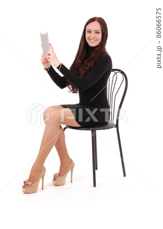Girl sits on a chair and holding a tablet computer 86066575