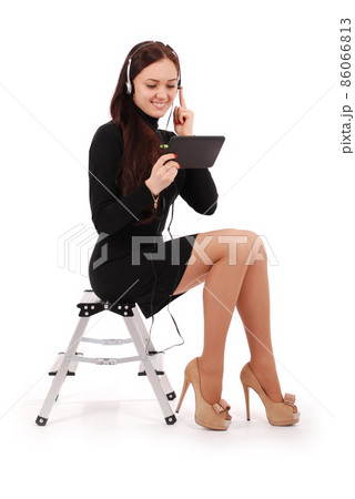 Happy student teenage girl sitting on the ladder looking at tablet pc at headphones 86066813