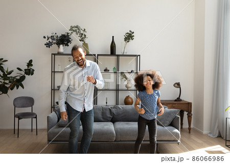 Happy millennial Afro American father teaching girl to dance Happy millennial Afro American father teaching girl to dance 86066986
