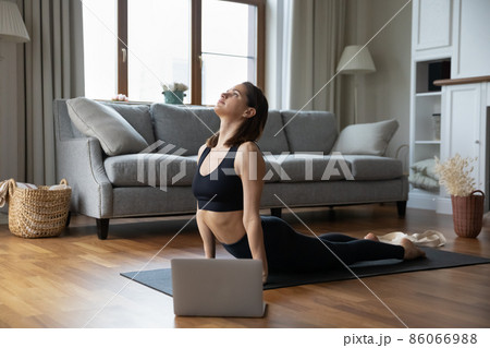 Concentrated young yogi girl practicing yoga at home Concentrated young yogi girl practicing yoga at home 86066988