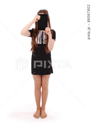 Girl keeps tablet pc in front of face 86067802