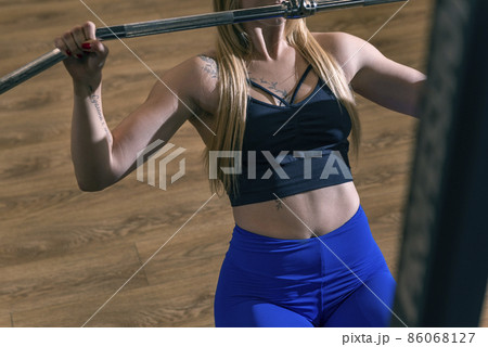 Sporty woman doing thrust of upper block to chest. Girl doing workout exercise with thrust of Pulldown. 86068127
