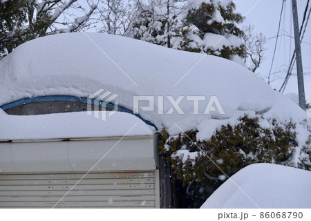 車庫の屋根に多く積もった雪 86068790