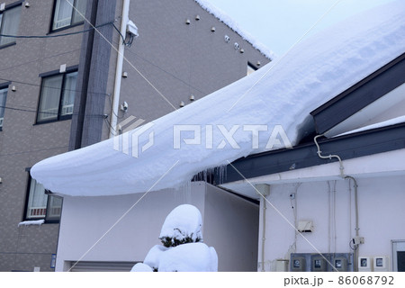 住宅の屋根に積もった雪 86068792