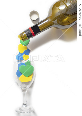 Valentine's Day backgrounds. Multi-colored hearts are poured into a glass from a bottle. isolated on white 86069215