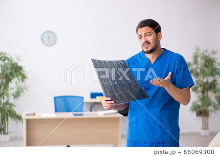 Young male doctor radiologist sitting in the clinic Young male doctor radiologist sitting in the clinic 86069300