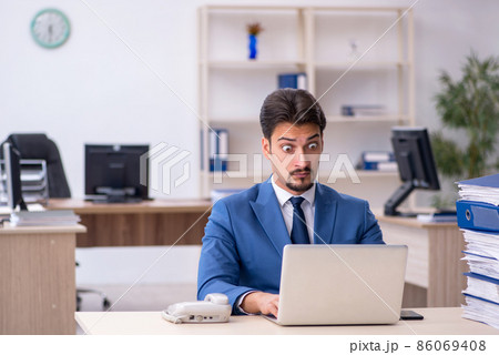 Young businessman employee unhappy with excessive work in the of 86069408