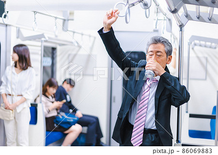 電車内で飲酒をする中年の男性 86069883