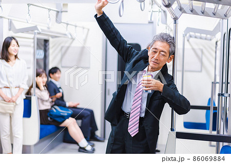 電車内で飲酒をする中年の男性 電車内で飲酒をする中年の男性 86069884
