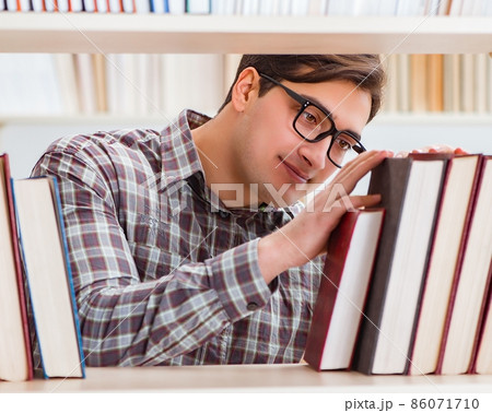 Young student looking for books in college library Young student looking for books in college library 86071710