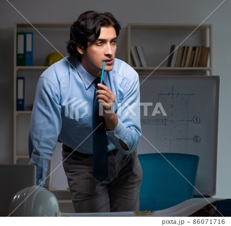 The young male architect working night at office The young male architect working night at office 86071716