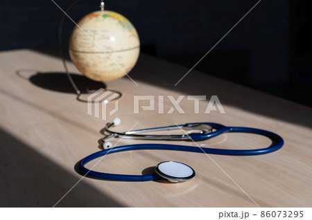 Globe and stethoscope. The concept of global warming and pollution. Phonendoscope and earth miniature. Stethophonendoscope. 86073295