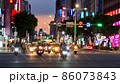 夕暮れ時の台北市の繁華街の交差点を走るバイク1 86073843