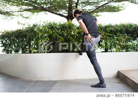 Asian active sportsman making a stretching before workout. 86075974