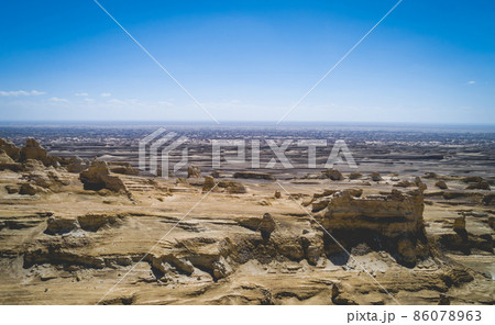 Aerial view of landscape in desert under blue sky Aerial view of landscape in desert under blue sky 86078963