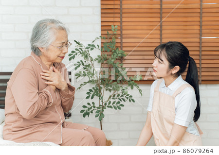 痛がる高齢者女性とエプロン姿の女性(胸) 痛がる高齢者女性とエプロン姿の女性(胸) 86079264