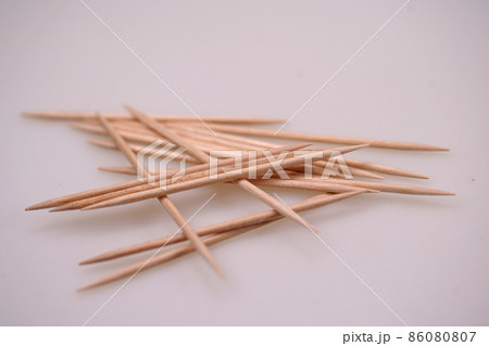 Closeup on a group of sharpt pointed wooden toothpicks against a white background in the studio Closeup on a group of sharpt pointed wooden toothpicks against a white background in the studio 86080807