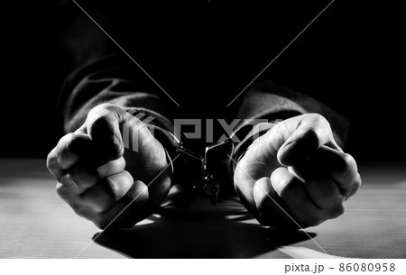 Arrested criminal hands locked in handcuffs. 86080958