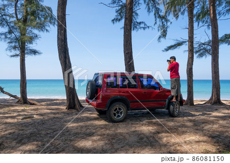 Young Asian male traveler and photographer standing on the car wheel 4x4 car and Taking photo sea beautiful beach in Phuket Thailand Travel photography concept Young Asian male traveler and photographer standing on the car wheel 4x4 car and Taking photo sea beautiful beach in Phuket Thailand Travel photography concept 86081150