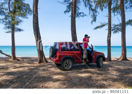 Young Asian male traveler and photographer standing on the car 4x4 car and Taking photo sea beautiful beach in Phuket Thailand Travel photography concept Young Asian male traveler and photographer standing on the car 4x4 car and Taking photo sea beautiful beach in Phuket Thailand Travel photography concept 86081151