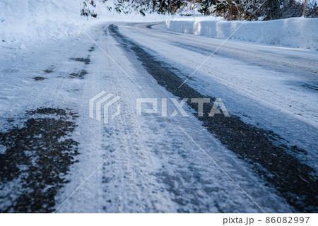 塩カルの撒かれた雪道 86082997