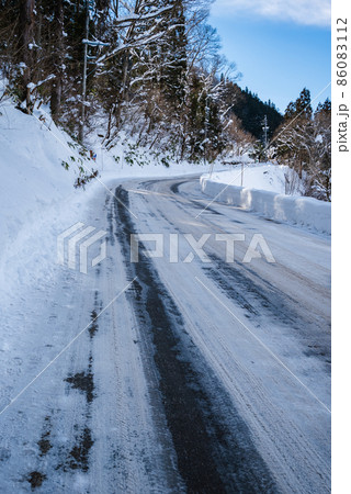 塩カルの撒かれた雪道 86083112