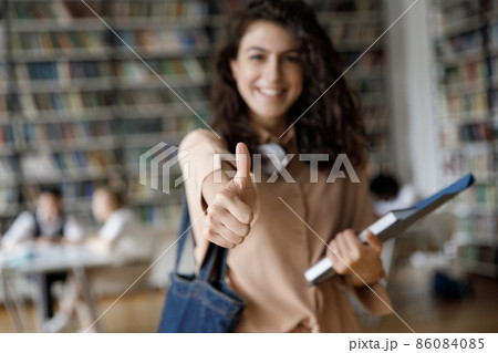 Happy satisfied college girl making thumb up, showing like Happy satisfied college girl making thumb up, showing like 86084085