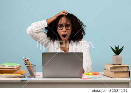 Deadline concept. Shocked black woman sitting at desk with laptop and grabbing her head, studying or working 86084151
