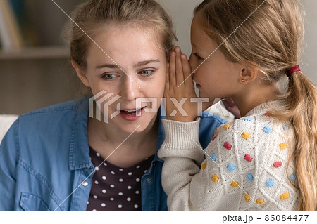 Joyful preteen girl telling secret to mum. Joyful preteen girl telling secret to mum. 86084477