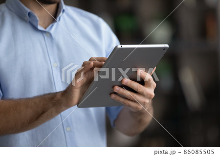 Crop close up man using modern tablet, typing on screen Crop close up man using modern tablet, typing on screen 86085505