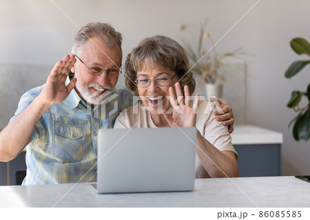 Happy middle aged grandparents holding video call conversation. Happy middle aged grandparents holding video call conversation. 86085585