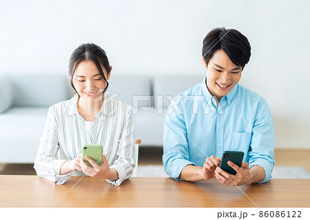 夫婦　カップル　スマホ　家族　ライフスタイル　リビング 86086122