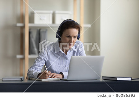Happy middle aged woman e-learning at home. 86086292