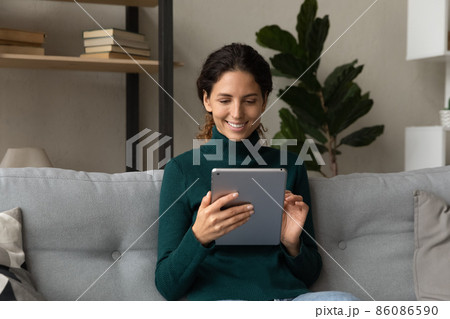Happy young latin woman using digital tablet. 86086590