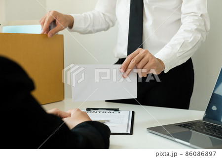 Desperately fired man office worker employee hands her employer her resignation letter and packs her belongings in a cardboard box concept dismissal and unemployment Desperately fired man office worker employee hands her employer her resignation letter and packs her belongings in a cardboard box concept dismissal and unemployment 86086897