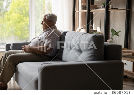 Relaxed happy old 80s man sitting on couch at home. 86087013