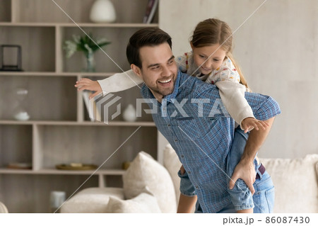 Happy father holding on back cute daughter. 86087430