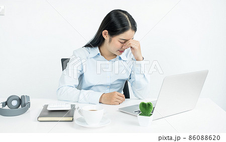 Working Asian women feel stressed, tired from work, migraine headaches from hard work while working at the office Working Asian women feel stressed, tired from work, migraine headaches from hard work while working at the office 86088620